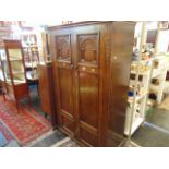 A carved Oak gents fitted wardrobe