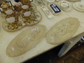 A pair of plaster plaques