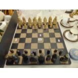 A decorative chess set and board, some pieces slight a.