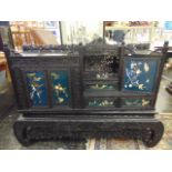 An Oriental carved and decorative side cabinet