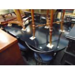 A Harrods black extending dining table and six chairs