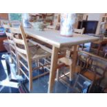 A pine table and four chairs with rush seats,