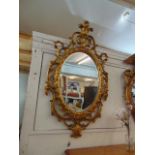 A fancy gilt oval mirror