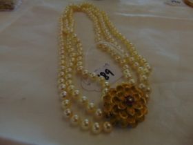 A three row Pearl necklace with 18ct Gold Chrysanthemum clasp set with Diamond and Ruby