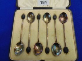 A boxed set of enamel and Silver spoons