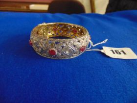 A White metal bangle, set with Rubies and Diamonds, approx.