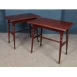 A pair of mahogany tables with turned supports.