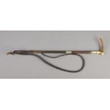 A carved bone/horn handled leather riding crop with plaited leather whip.