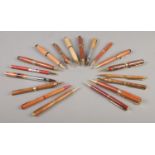 A collection of approximately twenty wooden bodied ball-point pens and propelling pencils.