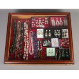 A large bijouterie cabinet containing a good collection of costume jewellery. To include earrings,