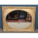 A large gilt painted ornate mirror, with beveled oval insert (124cm x 98cm). Cracks to gilt paint,