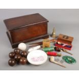 A mahogany box with contents of collectables. Includes carpet bowls, Mauchline ware box, compact,