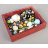 A small box of mainly glass marbles.