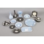 A quantity of Wedgwood jasperware in both blue and black, including quartz clocks, posy vases