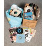 A bag and a box of single records. Includes mainly Pop examples, Adam & The Ants, Paul Simon, Soft