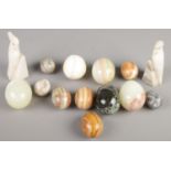 A collection of hardstone eggs along with a pair of hardstone parrot book ends.