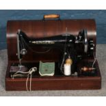 A dome top cased singer sewing machine, with manual.