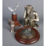 Four pieces of metalware. Including large seated monkey, wall plaque formed as a native American