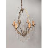 A decorative brass five branch chandelier with glass lustre drops.