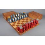 Hand carved and painted wooden chess set and board, together with two wooden storage boxes. Board