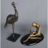A gilt metal sculpture formed as a seated nude figure along with a oriental bronze of a crane.