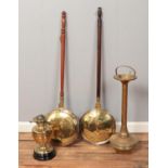 A collection of metalwares. Includes two bed warming pans, a brass smoker's stand and an oil lamp