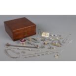 A mahogany box containing an assortment of silver jewellery, to include brooches, identity bracelet,