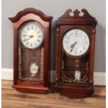 A London Clock Co. pendulum wall clock along with Rhythm Quartz pendulum clock.