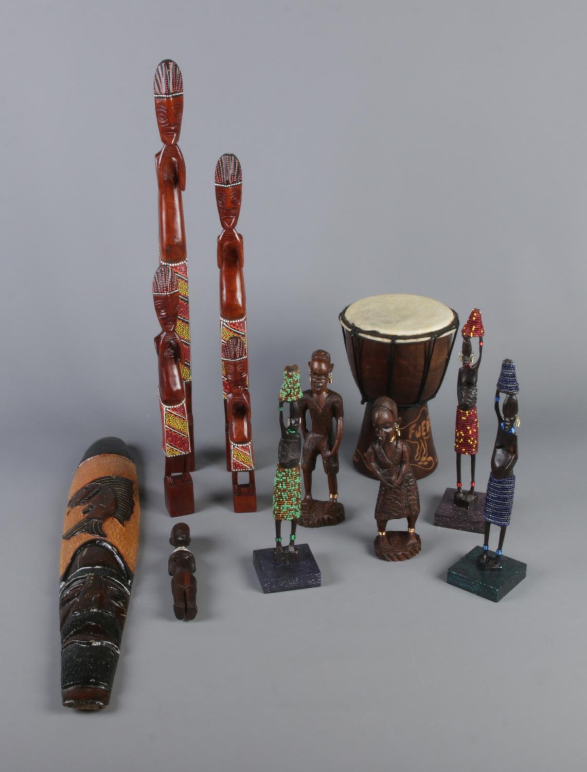 A quantity of carved tribal figures and miniature djembe drum.