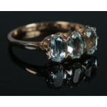 A 9ct Gold and three stone aquamarine dress ring. Size NÂ½. Total weight: 1.96g.