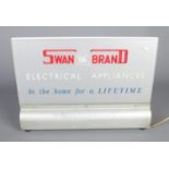 A light up shop window sign for "Swan Brand Electrical Appliances - In the Home for a Lifetime",