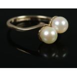 A 9ct Gold and Pearl 'Moi et Toi' ring. Size KÂ½. Total weight: 1.9g.