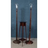 A mahogany two tier jardiniere stand along with two turned wooden standard lamps.