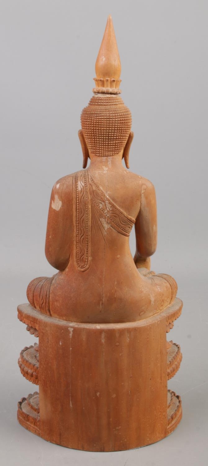 A carved wooden figure of a seated Buddha. 31.5cm. - Image 3 of 3