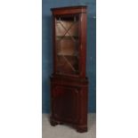 A mahogany corner cabinet, with astragal glazed panel and hinged lower cupboard door. Height: 180cm,