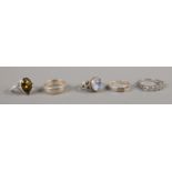 Five silver rings, to include Cubic Zirconia set and belt buckle examples.