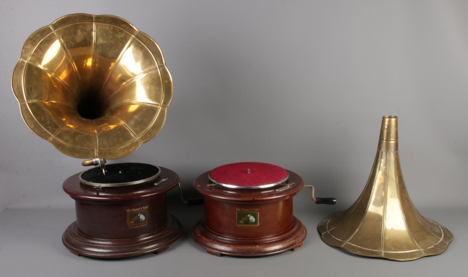 Two Vintage 'His Masters Voice' wooden gramophones on circular bases. Both with brass funnels, one