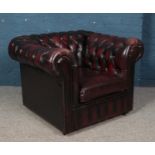 A deep buttoned oxblood leather Chesterfield style arm chair. Some wear to leather.