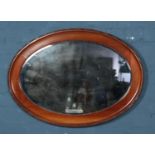 An oval mahogany framed bevel edged wall mirror.