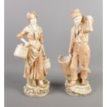 A large pair of Royal Dux style figures depicting a male and female workers carrying baskets.