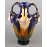 A Majolica style vase with four goat mask handles. (35cm) Crazing. Some small cracks under glaze