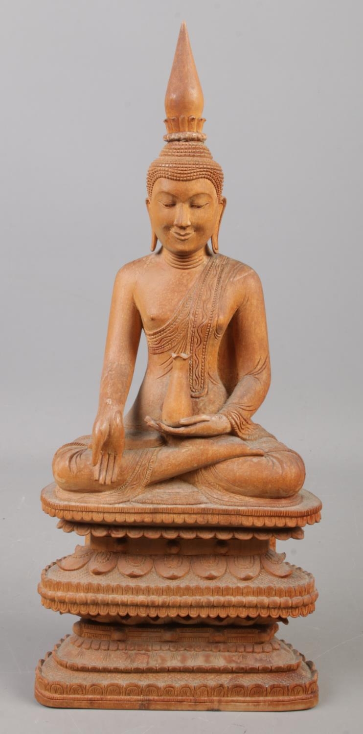 A carved wooden figure of a seated Buddha. 31.5cm.