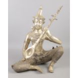 A large Thai white metal sculpture of a seated deity playing a sitar. 40cm.