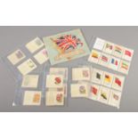 A collection of Kensitas silk cards in sleeves and an album. Includes flags and flowers.