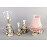 Four assorted table lamps including several marble examples, one with pink fringe shade.