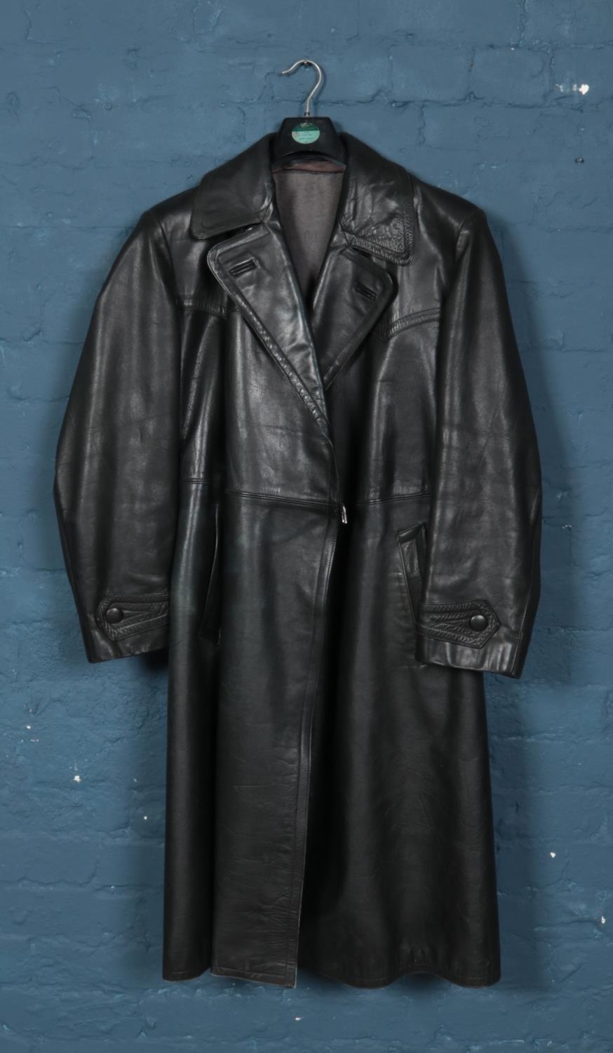 A black leather German full length coat, with fleece lining and bearing Swastika badge to inside