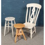 A painted kitchen chair along with a painted stool and one other stool.