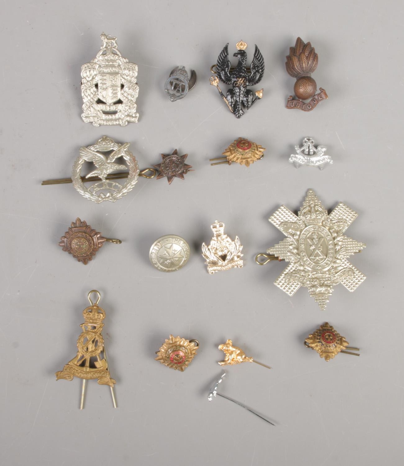 A quantity of military cap badges and pins including The Royal Highlander Black Watch, King Edward's