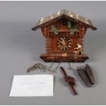 A German Regula pendulum cuckoo clock in the form of a carpenters house.