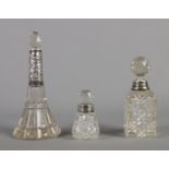 Three silver collared cut glass scent bottles. Hallmarked Birmingham 1907, Birmingham 1893 and one